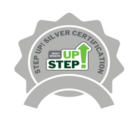 Silver circular badge with jagged edges containing the text